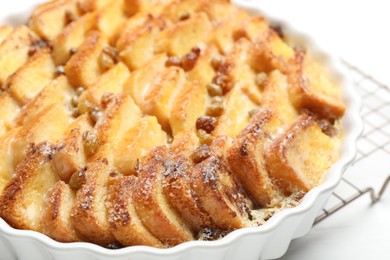 Photo of Delicious bread pudding with raisins on white table, closeup