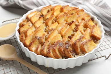 Photo of Delicious bread pudding with raisins and condensed milk on white table, closeup