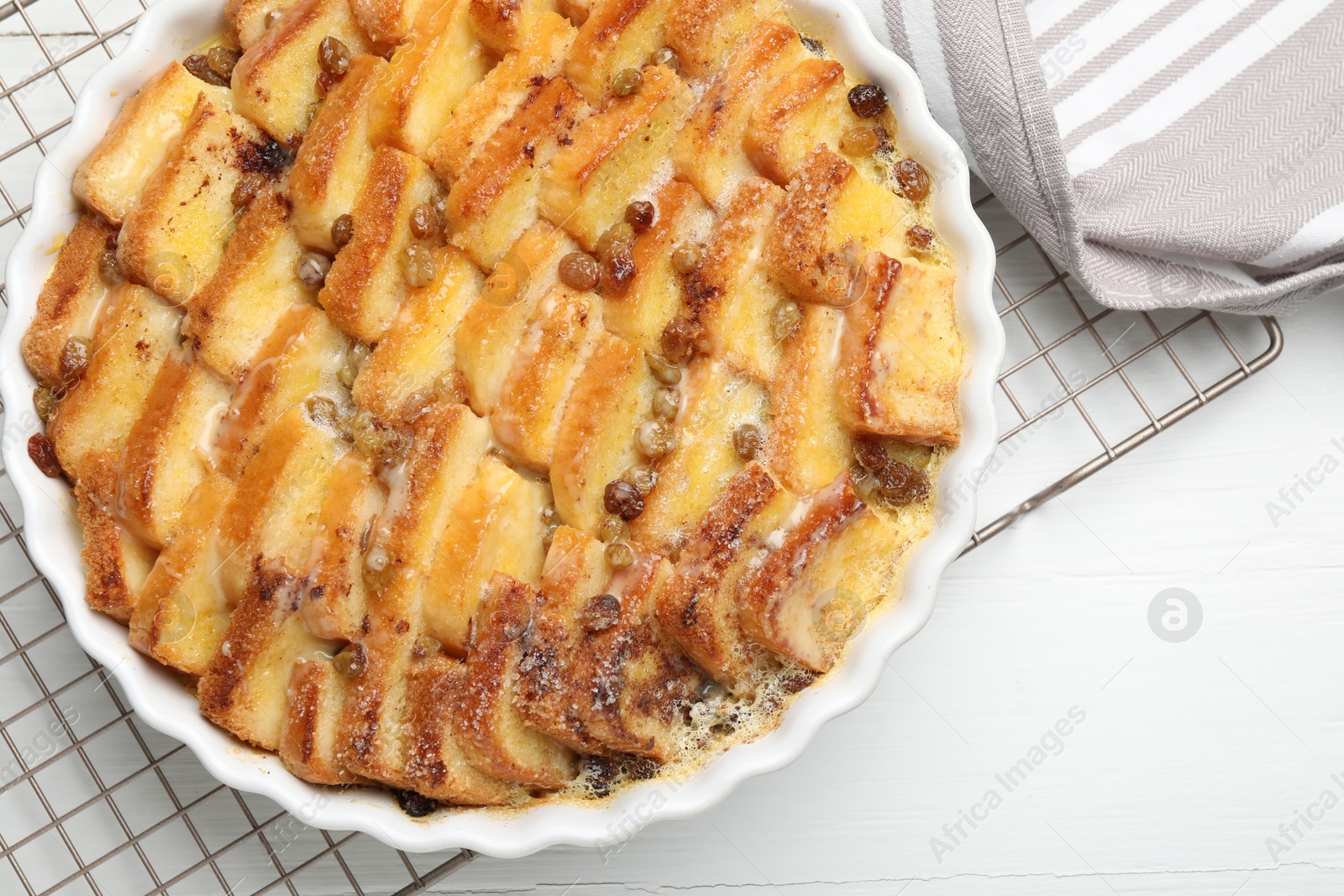 Photo of Delicious bread pudding with raisins on white table, top view