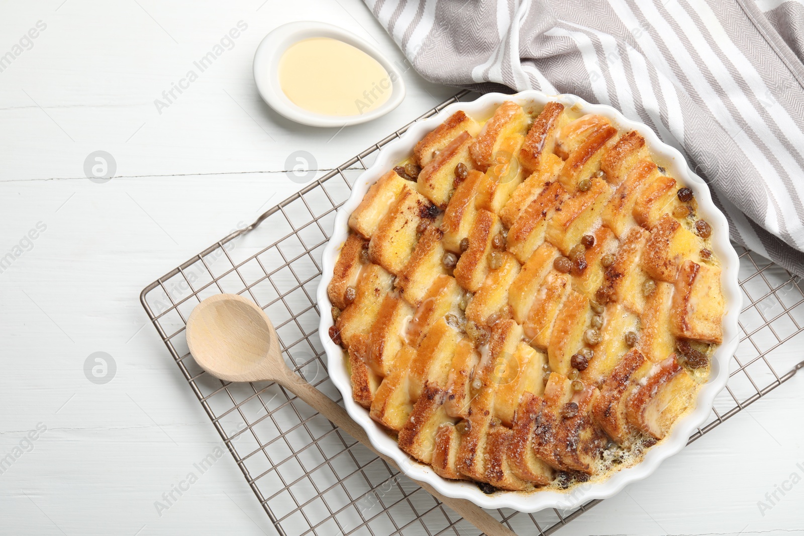 Photo of Delicious bread pudding with raisins and condensed milk on white table, flat lay