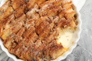 Photo of Delicious bread pudding with raisins and cinnamon on grey table, top view