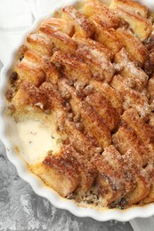 Photo of Delicious bread pudding with raisins and cinnamon on grey table, top view