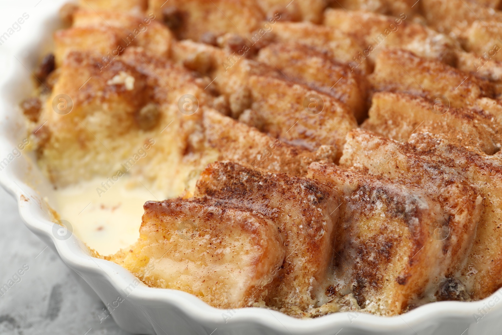 Photo of Delicious bread pudding with raisins and cinnamon on table, closeup