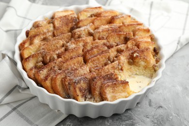 Photo of Delicious bread pudding with raisins and cinnamon on grey table, closeup