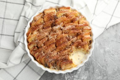 Photo of Delicious bread pudding with raisins and cinnamon on grey table, top view