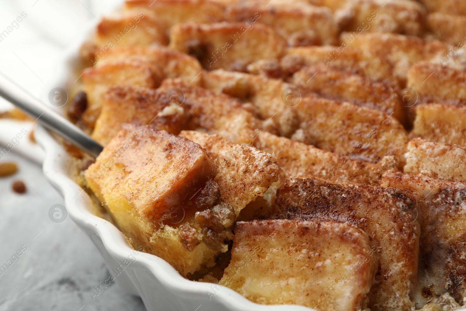 Photo of Delicious bread pudding with raisins and cinnamon on table, closeup