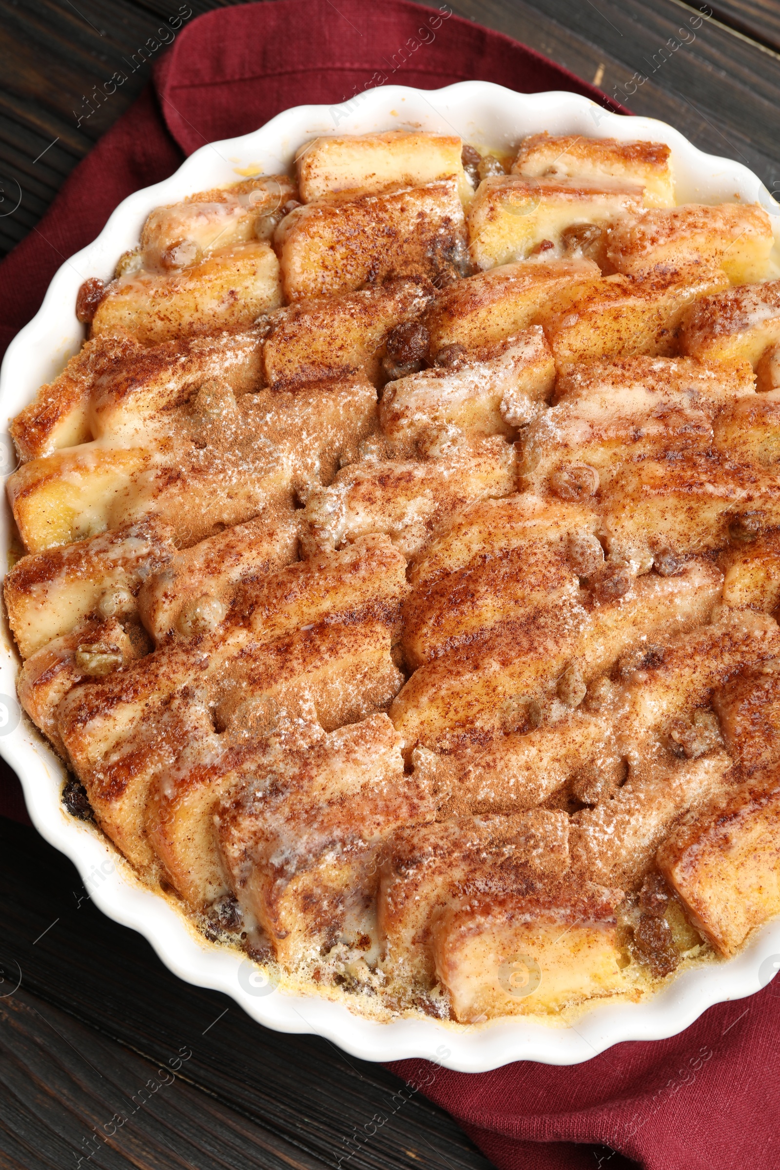 Photo of Delicious bread pudding with raisins and cinnamon on wooden table, top view