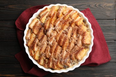 Photo of Delicious bread pudding with raisins and cinnamon on wooden table, top view