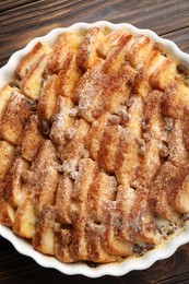 Photo of Delicious bread pudding with raisins and cinnamon on wooden table, top view