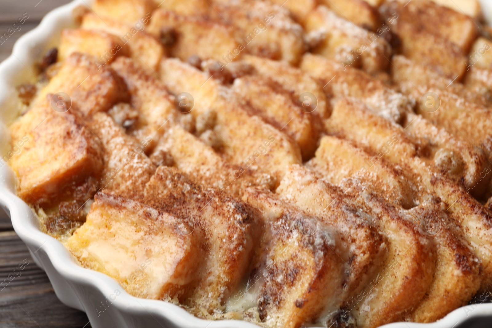 Photo of Delicious bread pudding with raisins and cinnamon on table, closeup