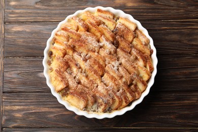 Photo of Delicious bread pudding with raisins and cinnamon on wooden table, top view