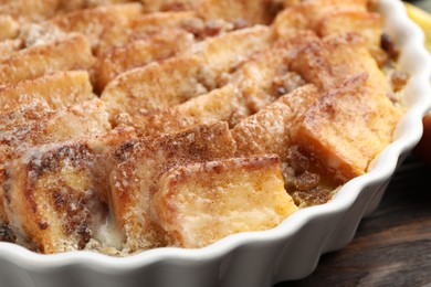 Photo of Delicious bread pudding with raisins and cinnamon on wooden table, closeup