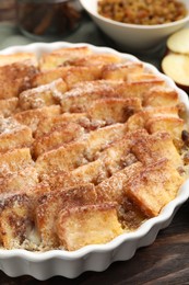 Photo of Delicious bread pudding with raisins and cinnamon on wooden table, closeup