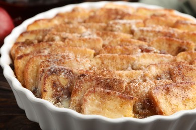 Photo of Delicious bread pudding with raisins and cinnamon on wooden table, closeup