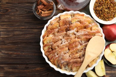 Photo of Delicious bread pudding with raisins, cinnamon and apples on wooden table, flat lay. Space for text