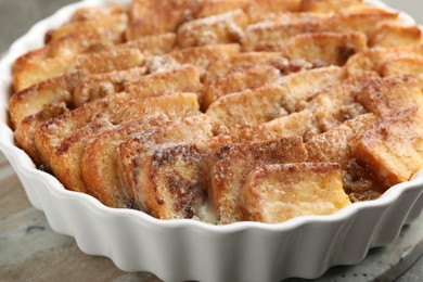 Photo of Delicious bread pudding with raisins and cinnamon on grey table, closeup