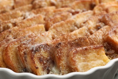 Photo of Delicious bread pudding with raisins and cinnamon in dish, closeup