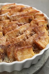 Photo of Delicious bread pudding with raisins and cinnamon on grey table, closeup