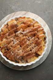 Photo of Delicious bread pudding with raisins and cinnamon on grey table, top view