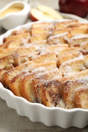 Photo of Delicious bread pudding with raisins and powdered sugar on grey table, closeup