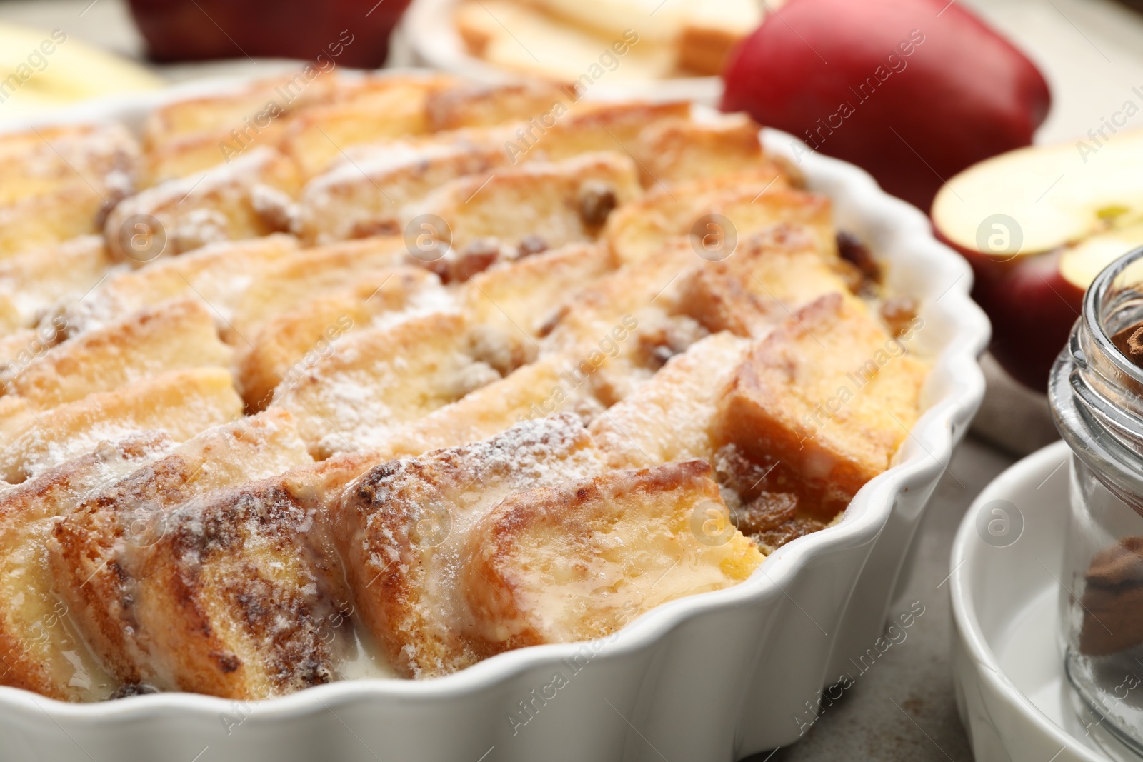 Photo of Delicious bread pudding with raisins and powdered sugar on table, closeup