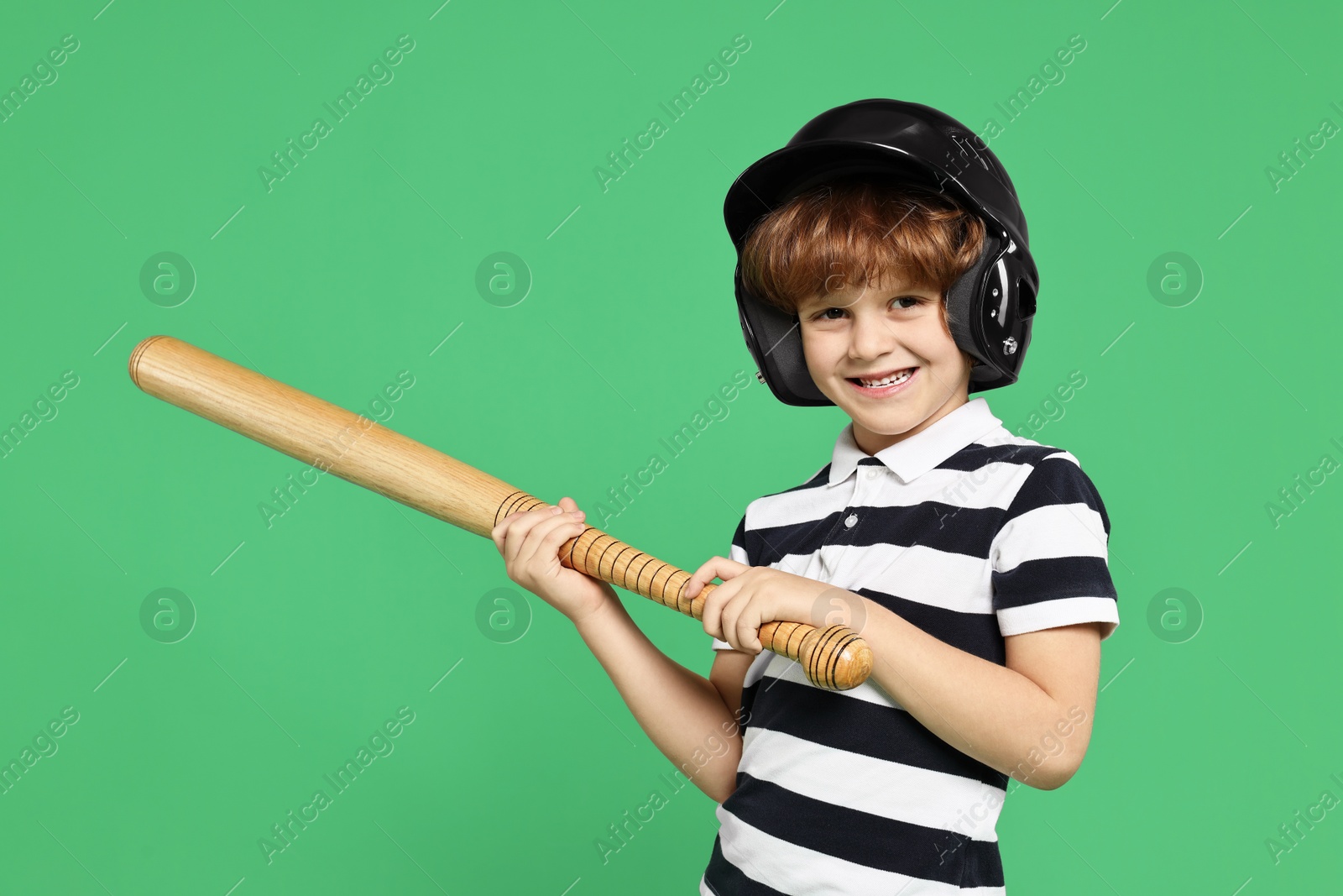 Photo of Little boy in helmet with baseball bat on light green background