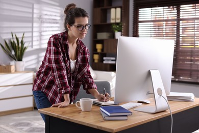 Beautiful woman working with computer at desk indoors. Home office