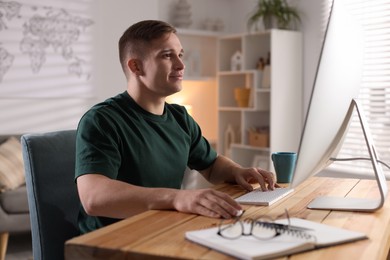 Photo of Handsome man working with computer at desk indoors. Home office