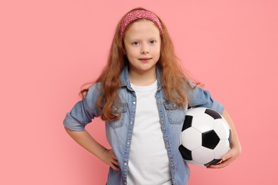 Photo of Little girl with soccer ball on pink background