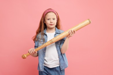 Photo of Little girl with baseball bat on pink background