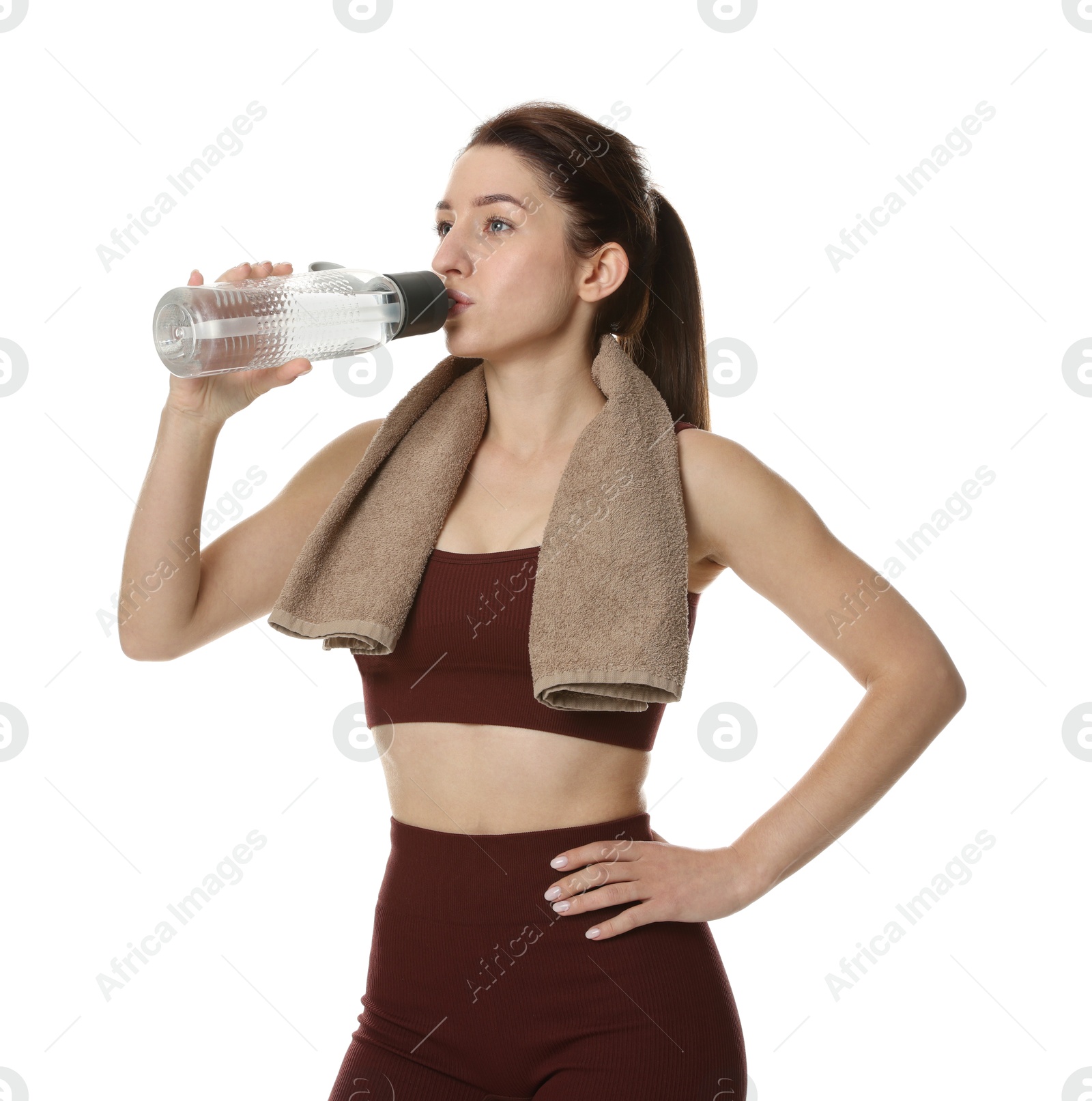 Photo of Woman in sportswear drinking water on white background