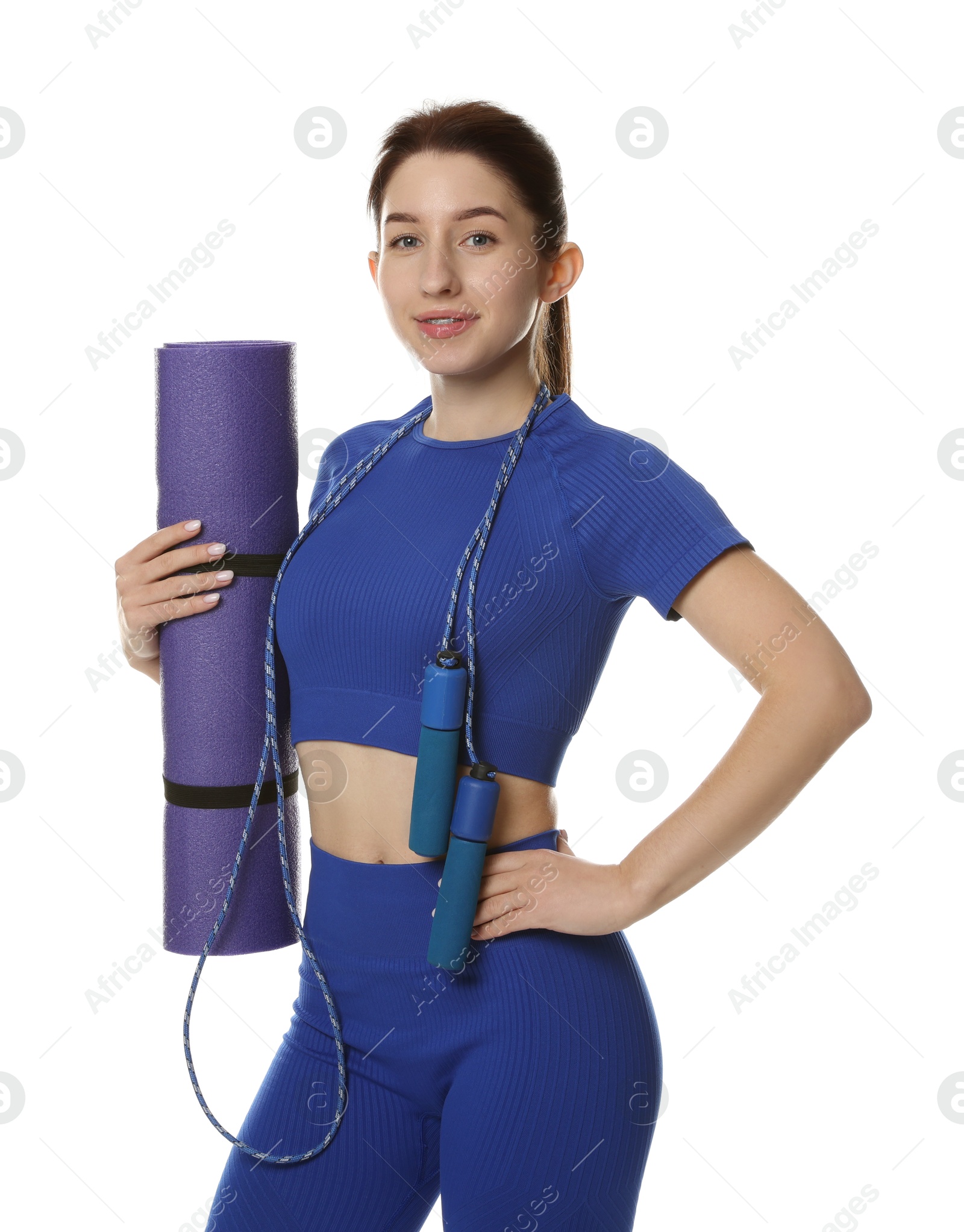 Photo of Woman in sportswear with fitness mat and skipping rope on white background