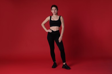 Photo of Portrait of woman in sportswear on red background