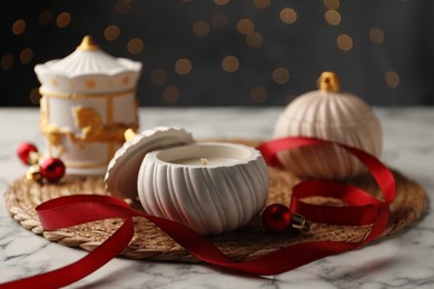 Photo of Soy wax candles on white marble table, closeup. Beautiful Christmas decor