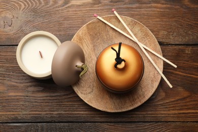 Photo of Soy candles and matches on wooden table, flat lay