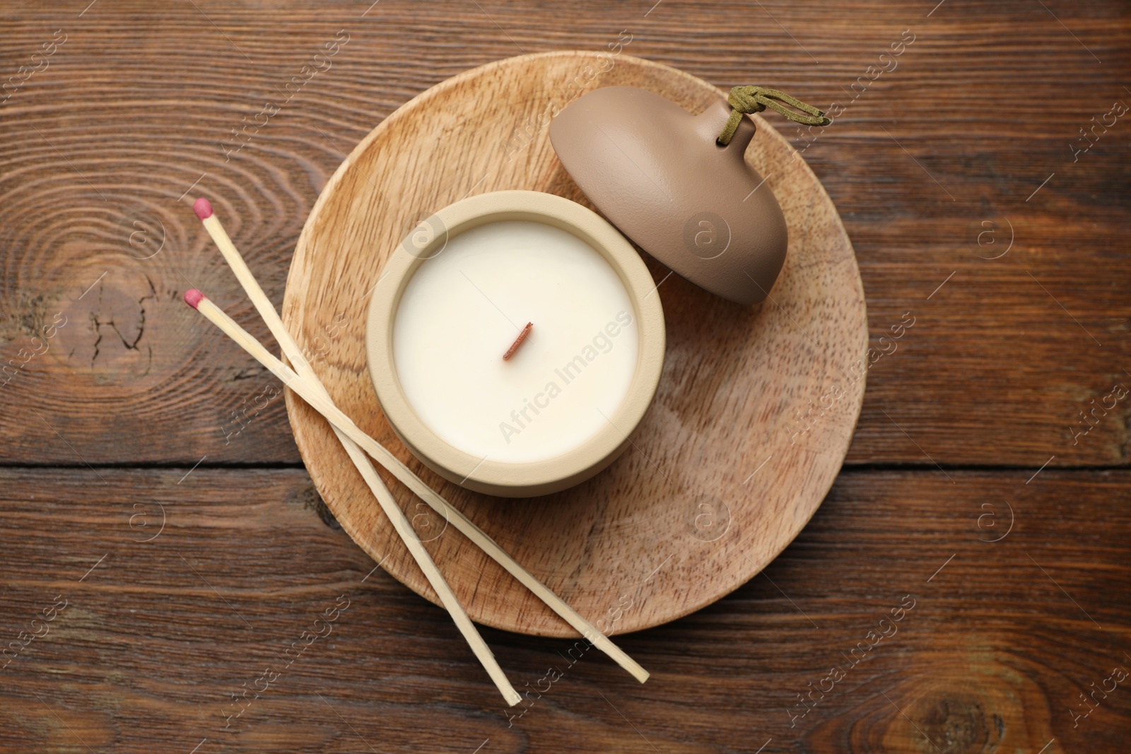 Photo of Soy candle and matches on wooden table, top view