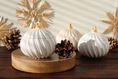 Photo of Soy wax candles and cones on wooden table. Beautiful christmas decor