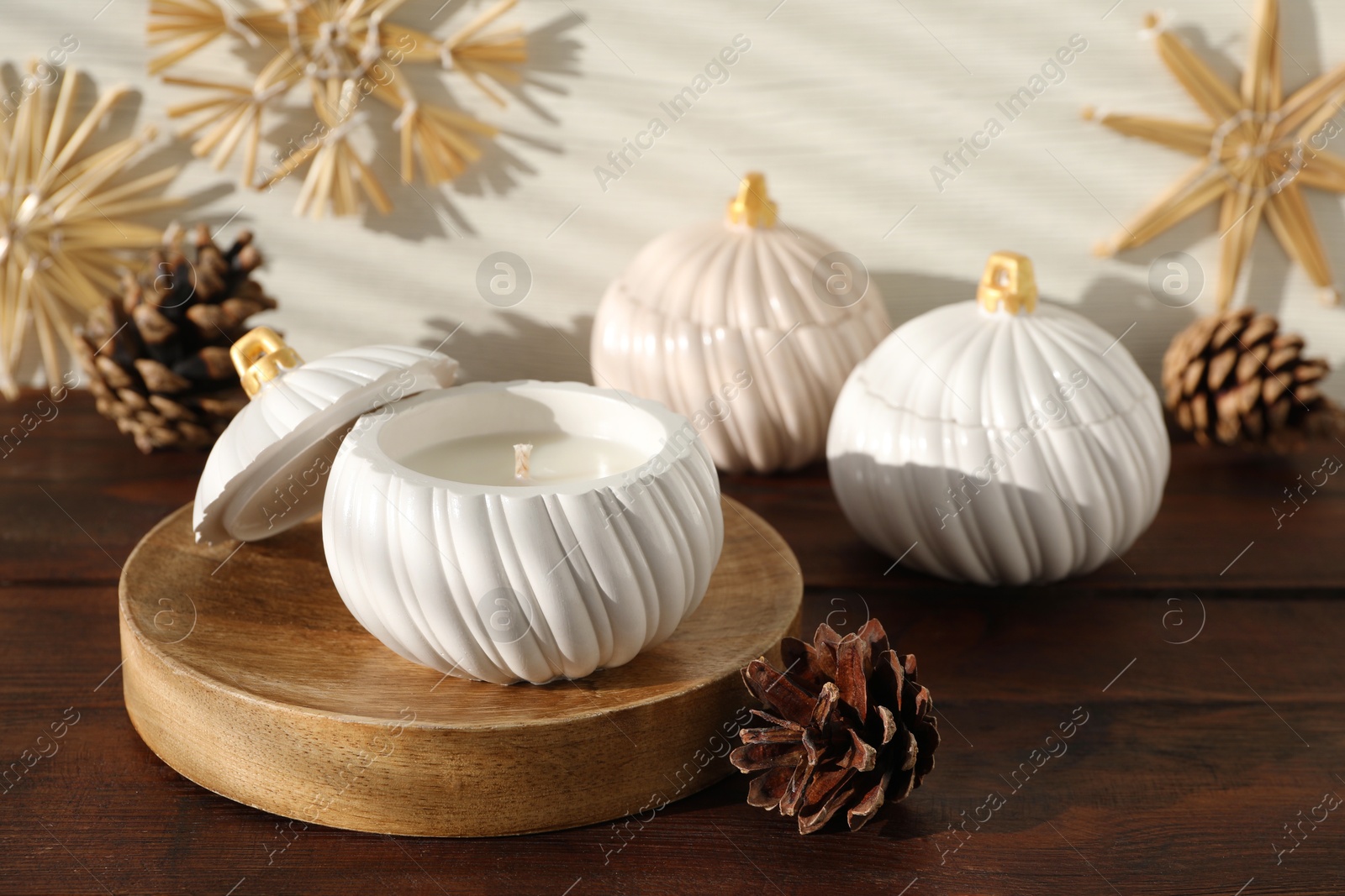 Photo of Soy wax candles and cones on wooden table. Beautiful christmas decor