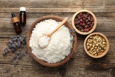 Photo of Soy wax in bowl and other different ingredients for making candles on wooden table, flat lay