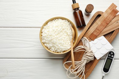 Photo of Soy wax, essential oils and different tools for making candles on white wooden table, flat lay. Space for text