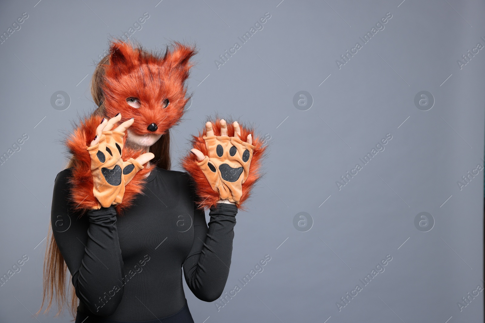 Photo of Quadrobics. Girl wearing fox mask and gloves on grey background, space for text