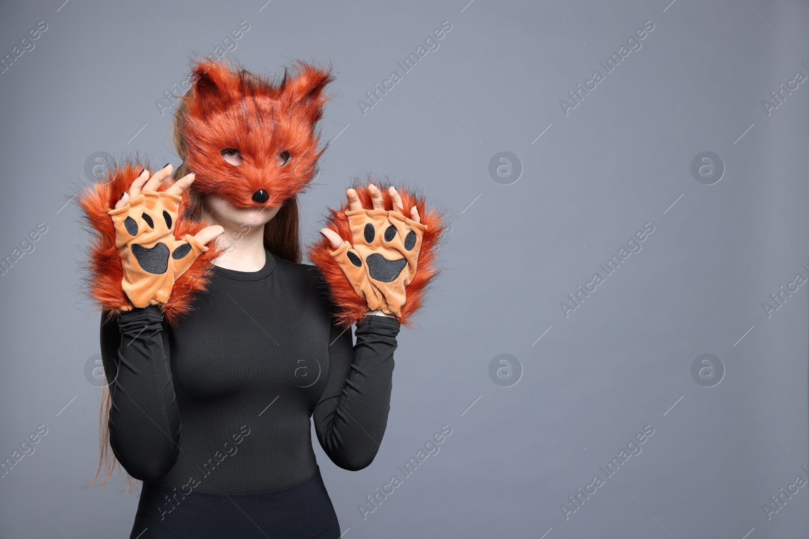 Photo of Quadrobics. Girl wearing fox mask and gloves on grey background, space for text