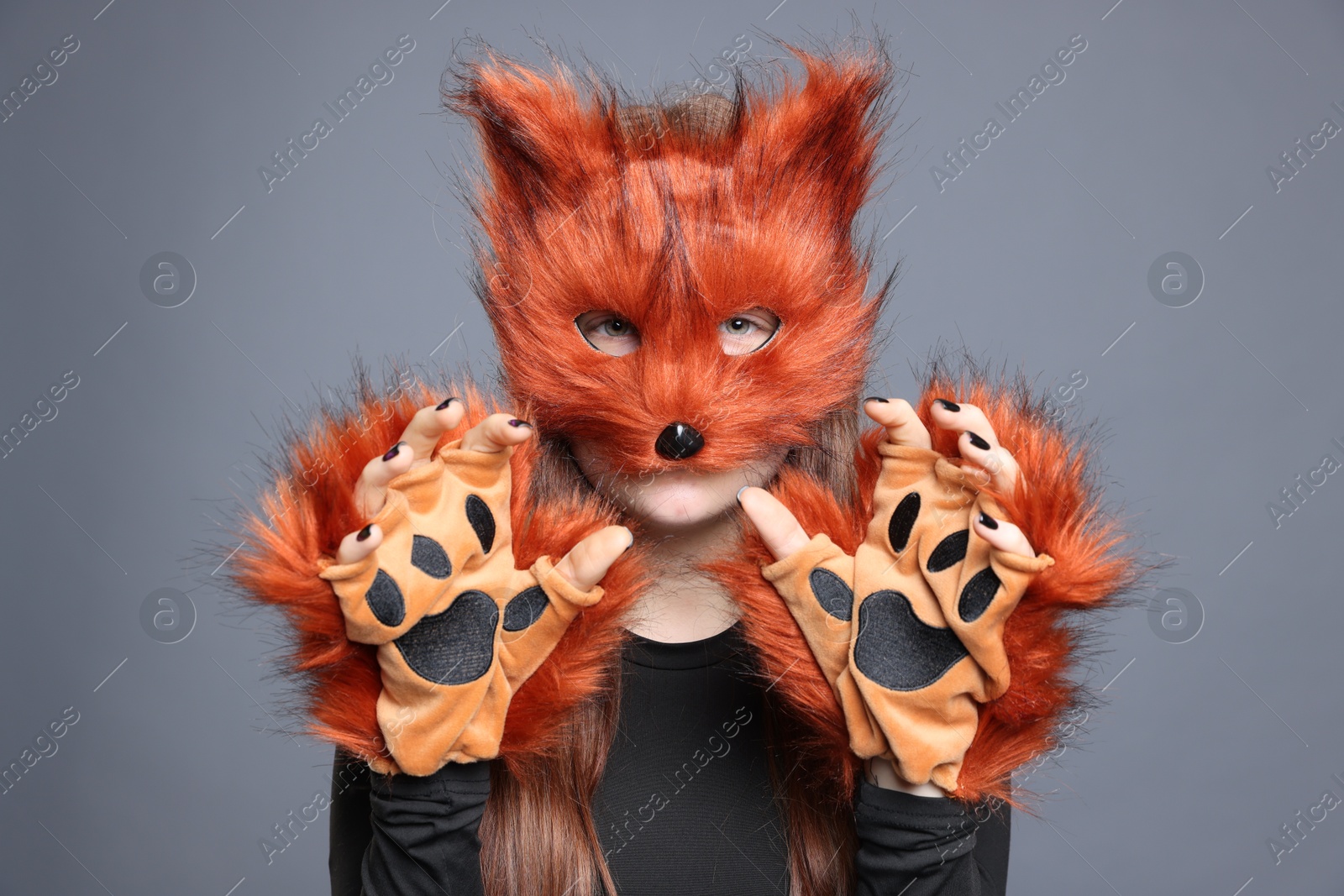 Photo of Quadrobics. Girl wearing fox mask and gloves on grey background