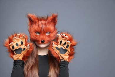 Photo of Quadrobics. Girl wearing fox mask and gloves on grey background, space for text