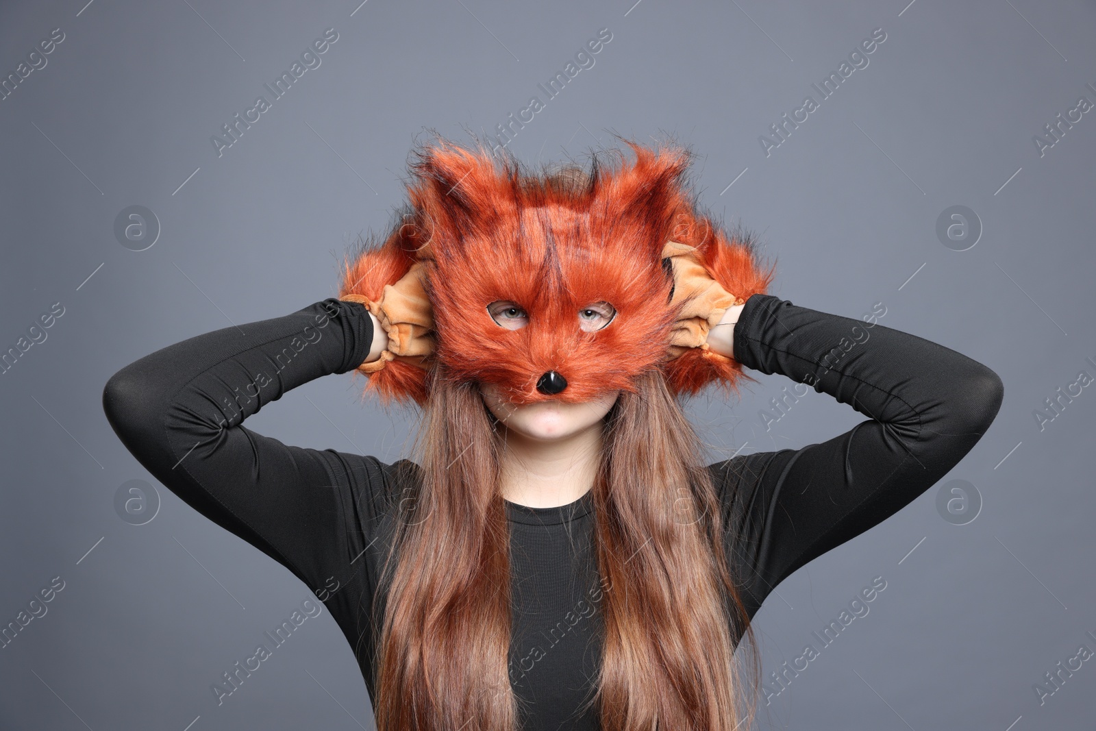 Photo of Quadrobics. Girl wearing fox mask and gloves on grey background