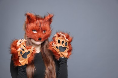 Quadrobics. Girl wearing fox mask and gloves on grey background, space for text