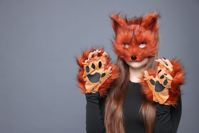 Photo of Quadrobics. Girl wearing fox mask and gloves on grey background, space for text