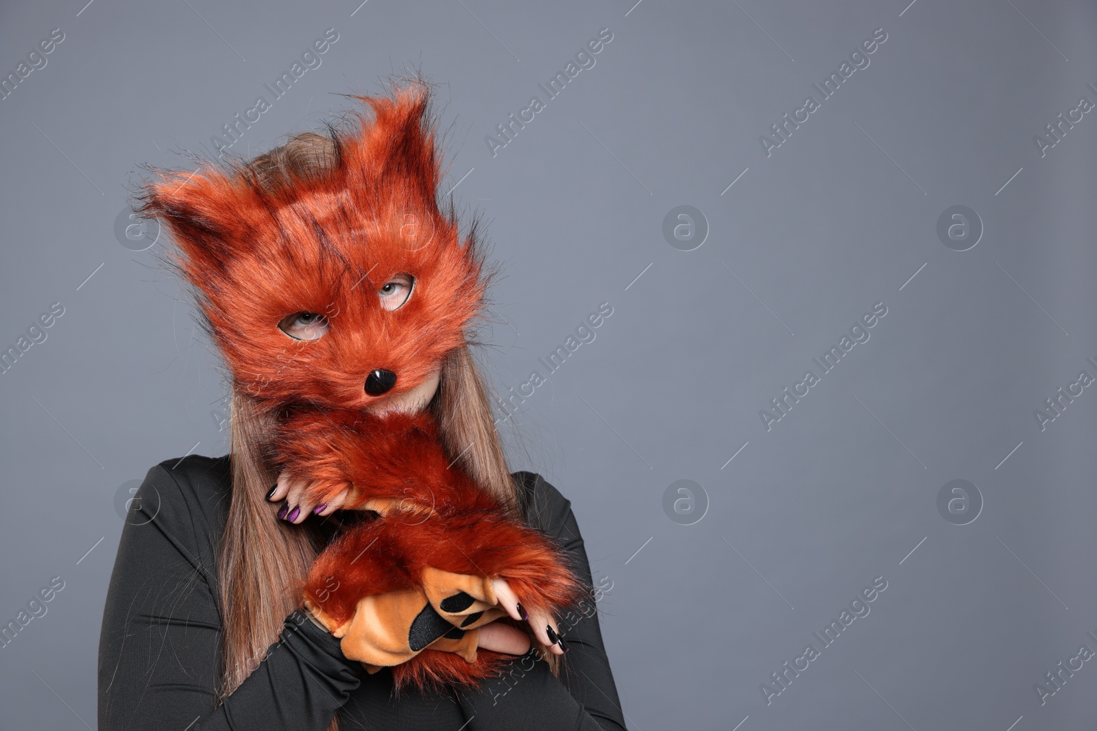 Photo of Quadrobics. Girl wearing fox mask and gloves on grey background, space for text