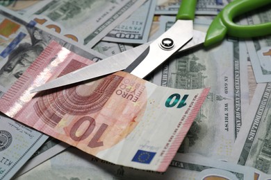 Photo of Different banknotes and scissors as background, closeup