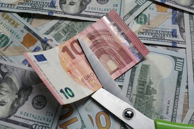 Photo of Different banknotes and scissors as background, top view